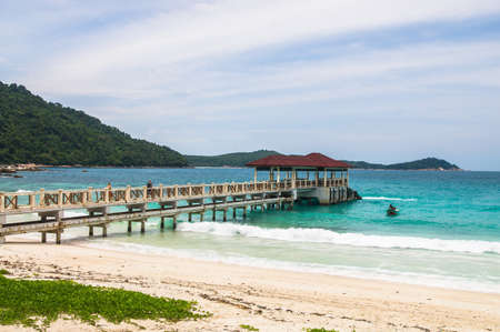 Relax on a deserted beach in an island of Tropical paradise. Pier on the beach at Pulau Perhentian, Malaysia.The boat approaches the shoreの写真素材