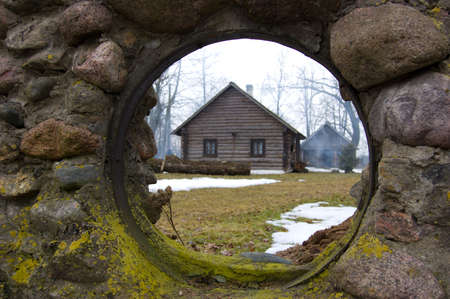 The house image through an aperture in a stone wallの写真素材