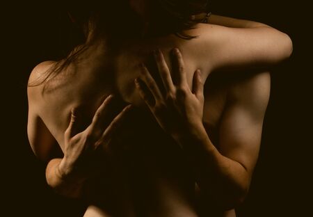 A sexual young topless couple male and female a dark backgroundの写真素材