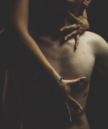 A sexual young topless couple male and female a dark backgroundの写真素材