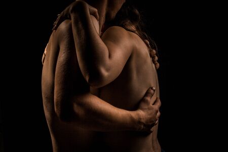 nude couple on a dark background hugsの写真素材