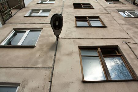view from below of street lamp on the wall of the house with windowsの写真素材