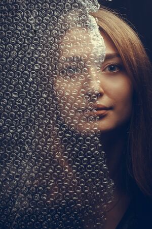 Abstract mysterious portrait girl hidden behind circle wrap in black background