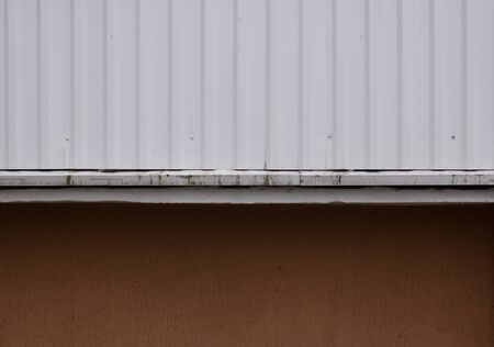 White painted metal or steel surface and plastered textured wall