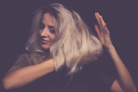 Studio portrait of a young beautiful girl on a black backgroundの写真素材