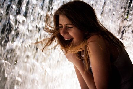 emotional portrait of a young brunette on the background of falling water
