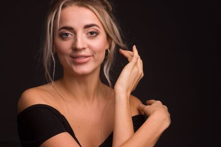Studio portrait of a young beautiful girl on a black background open, shoulders, cleavage.