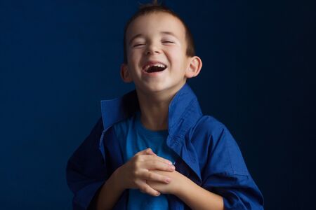 Studio portrait of boy in a blue classic sweater on a blue backgroundの写真素材