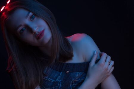 Fashionable Artistic Portrait Of A Beautiful Female Model In Bright Lights. Color gel photography