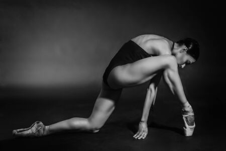 black and white dramatic vintage portrait of a girl, dancing ballerina in a black bodysuit in the Studio on gray backgroundの写真素材