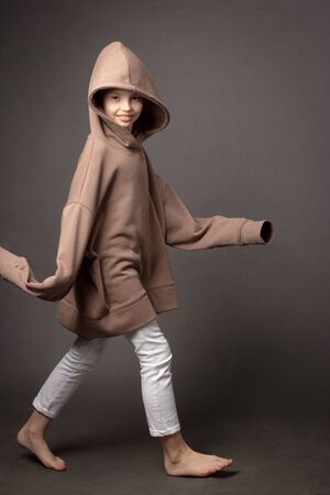 child-girl with long hair gathered in a bun. Portrait on a grey backgroundの写真素材