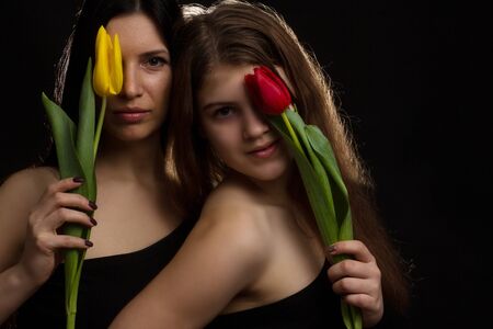 Portrait of girl and woman with tulips in the Studioの写真素材