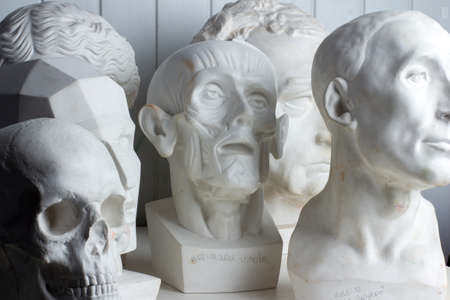 Belarus, Minsk, 16.04.2020 group classical plaster head bust against a white, old, worn wall. Artist's studioのeditorial素材