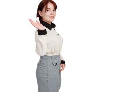 A young business woman, with short hair and a white blouse and a plaid skirt, smiling, hand raised, white background isolateの写真素材