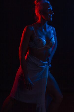 Portrait old woman in colorful bright lights. blue and red. in lingerieの写真素材