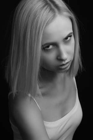 black-and-white portrait of a blonde on a black background.の写真素材