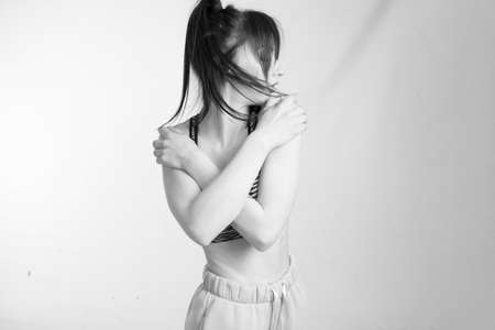 black and white photo, young athletic brunette woman in fitness clothes, isolated on whiteの写真素材