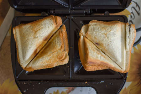 American hot cheese sandwich. Homemade sandwich with melted cheese on a sandwich maker.