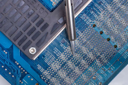 use a soldering iron to solder the electronic part to the Board. Computer repair. Macrophotography.