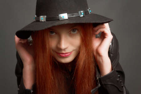 young rock style woman in black hat and leather jacket