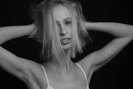 black-and-white portrait of a blonde on a black background.