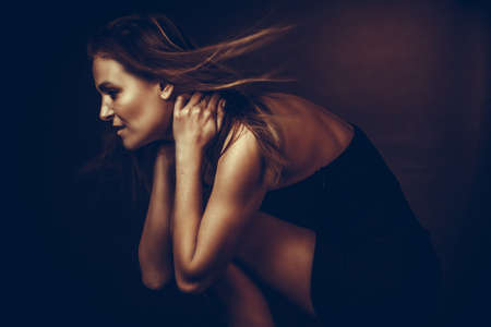 monochrome white portrait of an adult woman in a studio on a black background.の写真素材