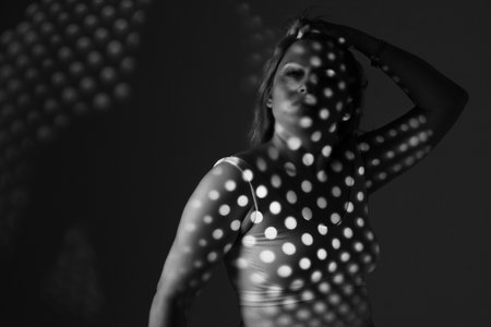 artwork portrait of an overweight woman. model posing in light of projector. Black and white retro monochrome photographyの写真素材