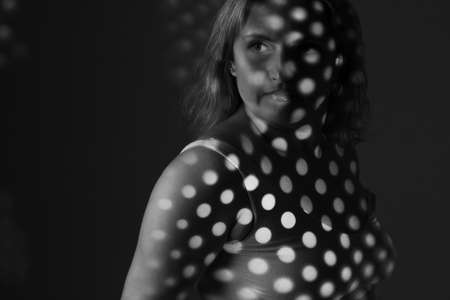 artwork portrait of an overweight woman. model posing in light of projector. Black and white retro monochrome photographyの写真素材