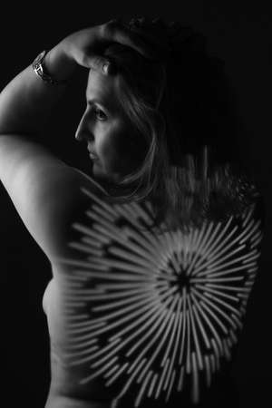 artwork portrait of an overweight woman. model posing in light of projector. Black and white retro monochrome photographyの写真素材