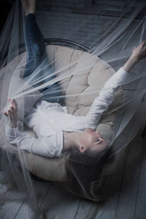 Studio portrait of a young woman with brown hair and long hair the veiled whiteの写真素材