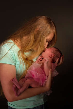 photo of a baby girl in a pink skirt and bow, with a blonde momの写真素材