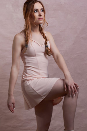 young beautiful caucasian woman, in a pink dress, on a pink backgroundの写真素材