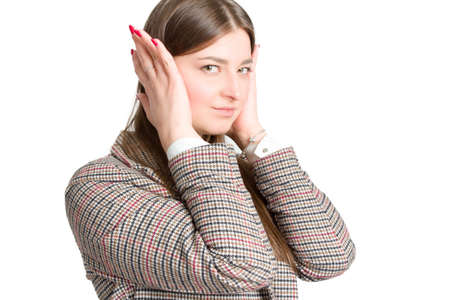 portrait of a young business woman in a plaid jacket. Isolate on white. puts her hands on the headの写真素材