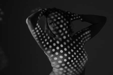 artwork portrait of an overweight woman. model posing in light of projector. Black and white retro monochrome photographyの写真素材