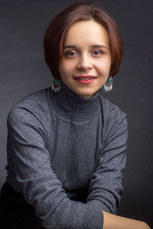 studio portrait a Young woman with short brown hair, in a gray sweaterの写真素材