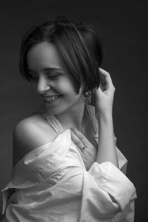 A young woman with short brown hair, wearing a white shirtの写真素材