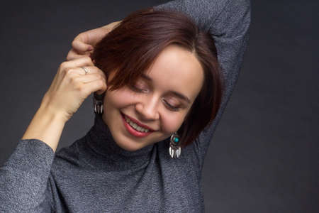 Young woman with short brown hair, in grey sweaterの写真素材