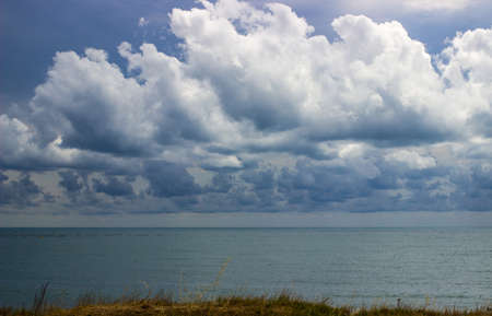 Landscape storm on the sea, dark cloudy sky, rocky coast of the sea, hurricanes in the ocean, rain,...
