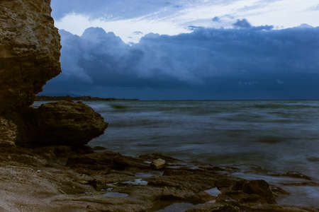 Landscape storm on the sea, dark cloudy sky, rocky coast of the sea, hurricanes in the ocean, rain, wind power, bad concept weatherの写真素材