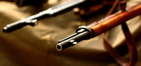 Old weapon guns on military background.の写真素材