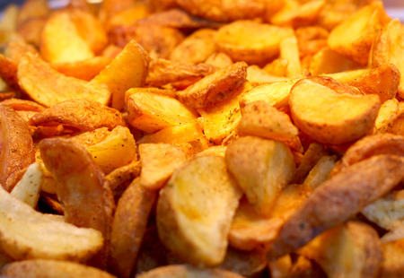 Large pan of natural food cooked sweet potato fries, fresh out of frying oil yellow colorful close up patternsの写真素材