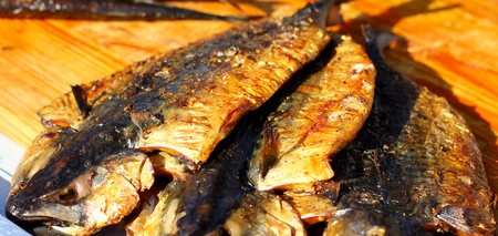 Smoked sea fish street fast food grill restaurant place on wooden deskの写真素材