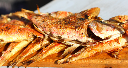 Fried sea fish street fast food grill restaurant place on wooden deskの写真素材