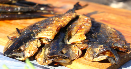 Smoked fish street fast food grill restaurant place on wooden deskの写真素材