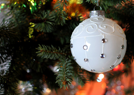 New Years and Christmas Eve celebration background with a light white ball decoration elegant arrangement, tree brunch. Copyspace. Bokeh light garland backdrops.の写真素材