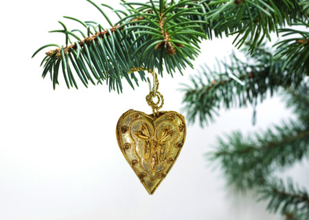 Christmas and New Year`s vintage retro toy decorations heart of the Gold tissue from glass on fir tree branches isolated on white background. Greeting card Background for holiday.の写真素材