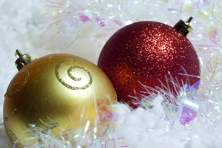 Christmas and New Year`s gold and red glow light decorations on snow. Greeting card white Background with holiday tinsel and copyspace place for text.の写真素材