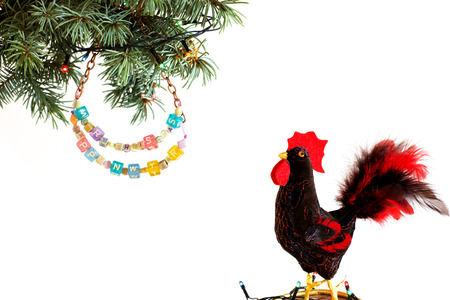 Happy New Year 2017 of rooster card with hand made craft red rooster and beaded letter garland and lights on Christmas tree branch isolated on white background. Copyspace place for text.の写真素材