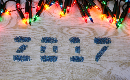 2017 Figures from glass beads on the white wooden background and garland big lights on top frame New Year and Christmas template copyspace card concept for price and description winter sale item.の写真素材