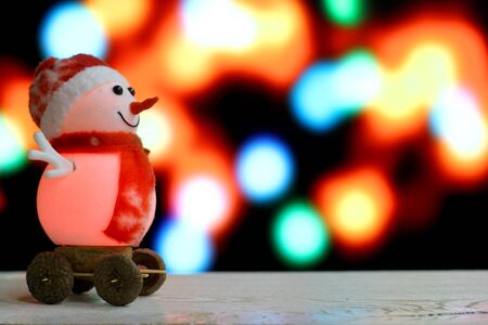 Christmas and New Year`s sale background with red snowmen slides on holiday bokeh lights. Foreground...